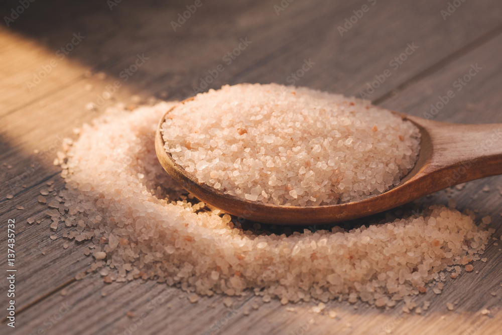 Himalayan pink rock salt in wooden spoon. Closeup. Sunny day Himalayan pink rock salt in wooden spoon. Closeup. Sunny day