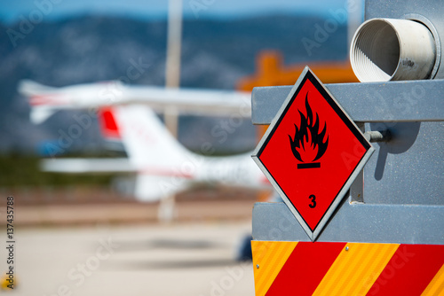 Rear view of service and refuelling truck on an airport with an aircraft in the blurry background. Chemical hazard, flammable liquids. photo