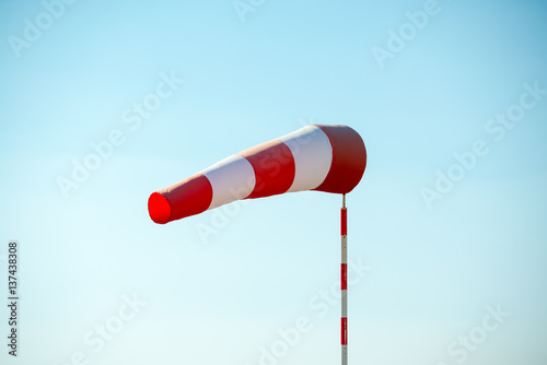 Horizontally flying windsock (wind vane) due to high wind. Blue sky in the background. Success concept. photo