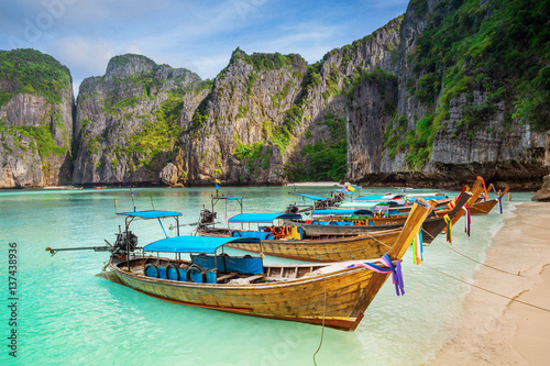 Thailand sea beach view round with steep limestone hills with many traditional longtail boats parking © happystock