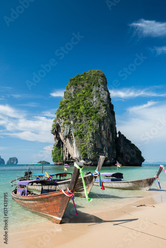 Colorful long tail boats at beautiful Ao Nang beach on a background of blue sky and azure sea and limestone rocks © happystock