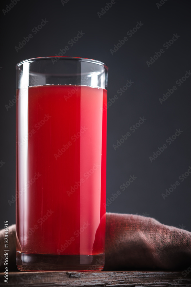 Cranberry drink in high glass on a grey background
