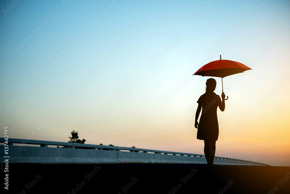 Silhouette women umbrella looking horizon.