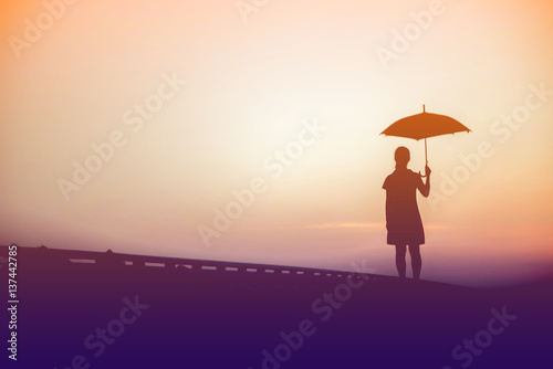 Silhouette women umbrella looking horizon.