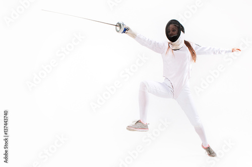 Man wearing fencing suit practicing with sword against gray © master1305