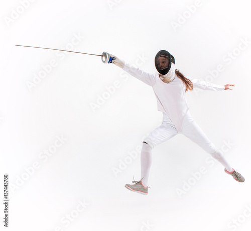 Man wearing fencing suit practicing with sword against gray © master1305