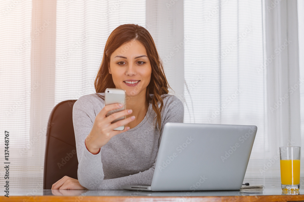 Girl using mobile phone at home office Girl using mobile phone at home office