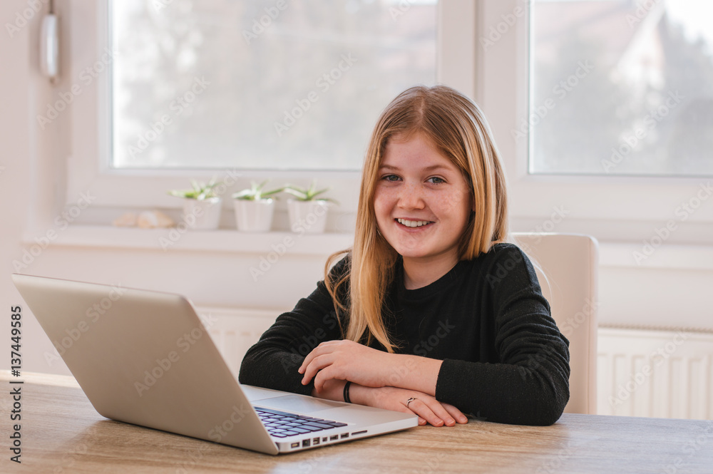 Portrait of smiling young girl with computer at home Portrait of smiling young girl with computer at home