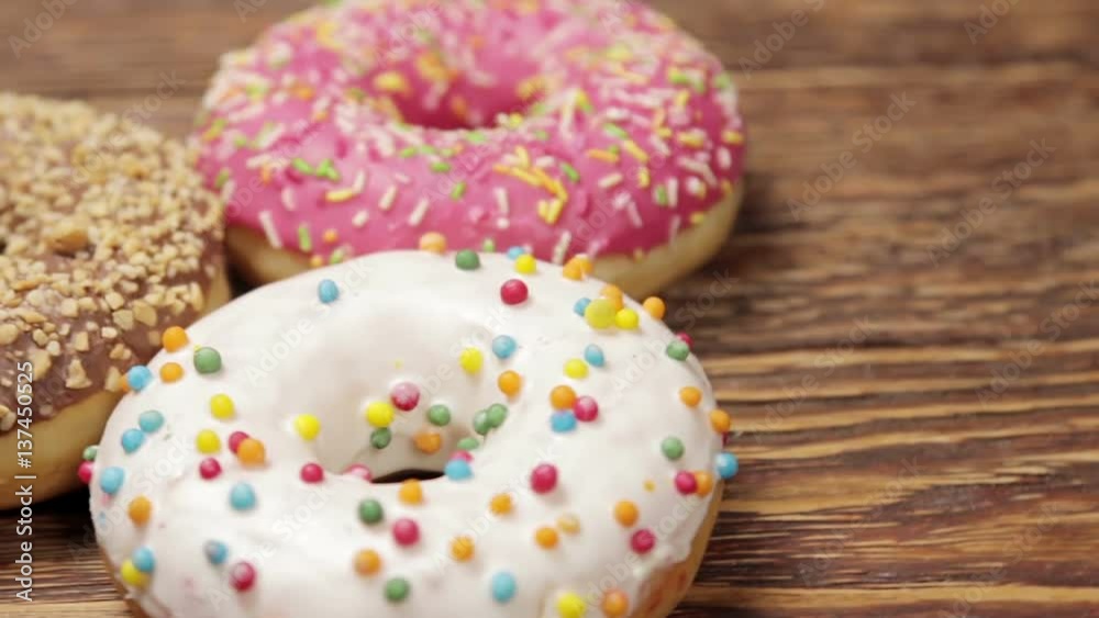 donuts with different fillings on the wooden table. video rotation