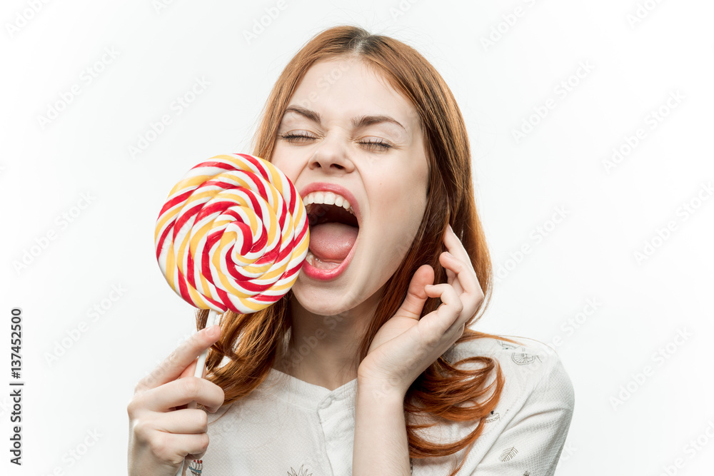 a woman with a lollipop in her hand opened her mouth wide