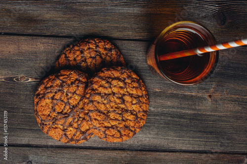 oatmeal cookies in chocolate glaze and a glass with a drink
