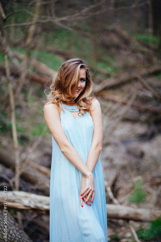 outdoor portrait of a beautiful brunette model in blue dress in the spring forest outdoor portrait of a beautiful brunette model in blue dress in the spring forest
