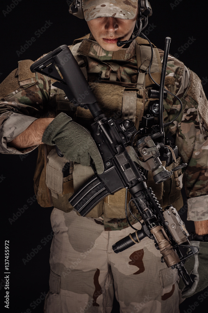 Portrait soldier or private military contractor holding sniper rifle. war, army, weapon, technology and people concept. Image on a black background.