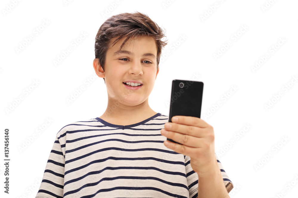 Boy looking at a phone and smiling Boy looking at a phone and smiling
