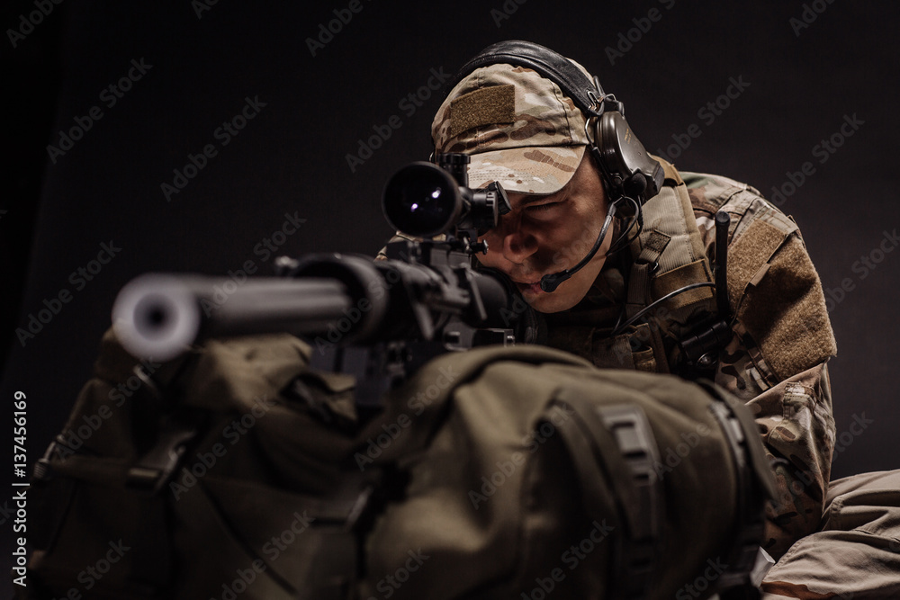 military contracto with his sniper rifle at night. war, army, weapon, technology and people concept