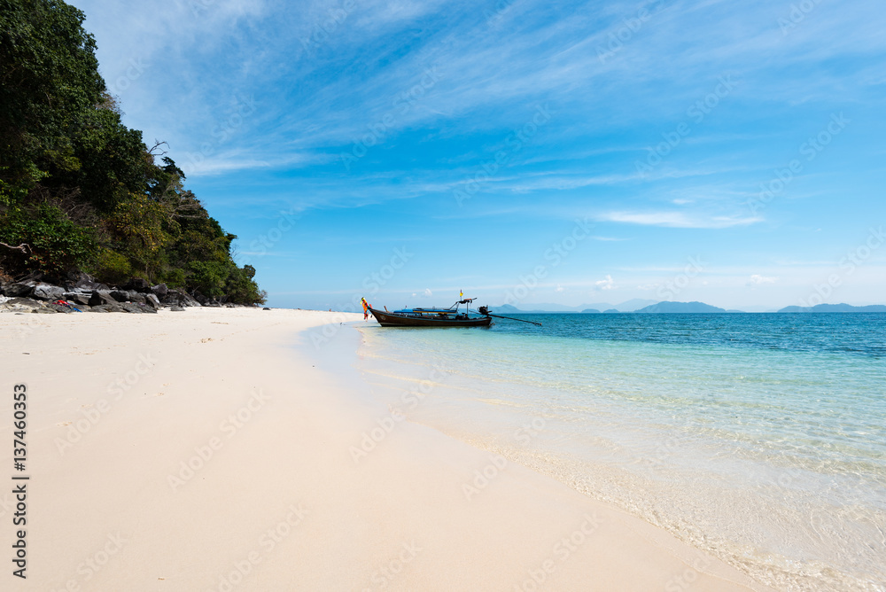 Thail longtail boat anchoring on white sand beach