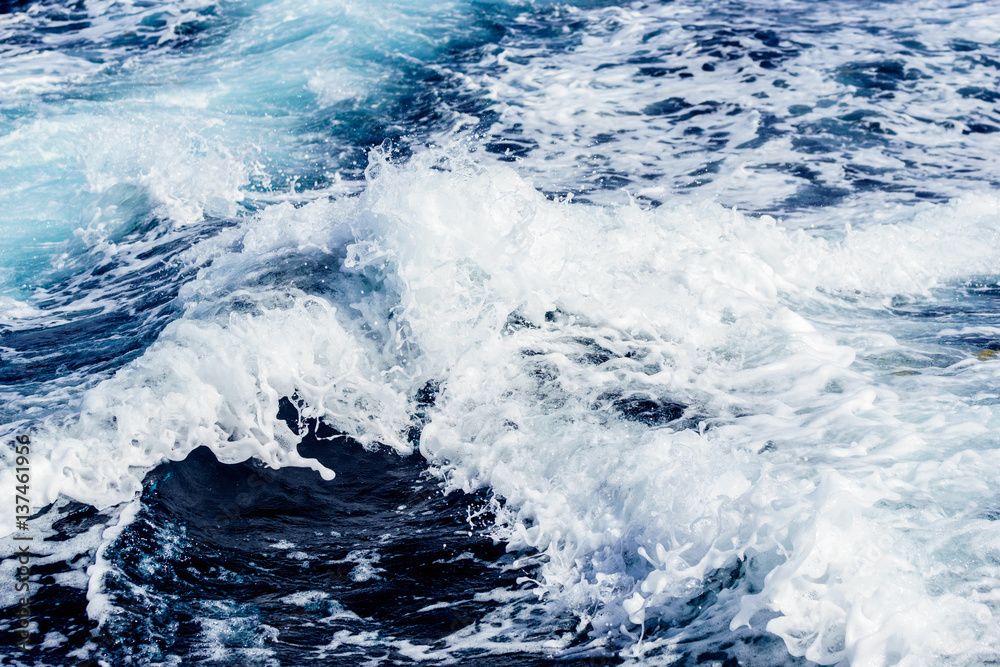 Atlantic ocean with blue water on a sunny day. Waves, foam and wake caused by cruise ship in the sea Atlantic ocean with blue water on a sunny day. Waves, foam and wake caused by cruise ship in the sea