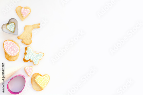 Colorful Easter homemade cookies with forms and pastry bag on white background