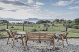 A sitting area with brown benches in front of the North Sea in the Scottish Highlands on the Isle of Skye.