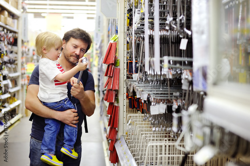 Fotografía Father and his son choosing the right tool in a hardware store