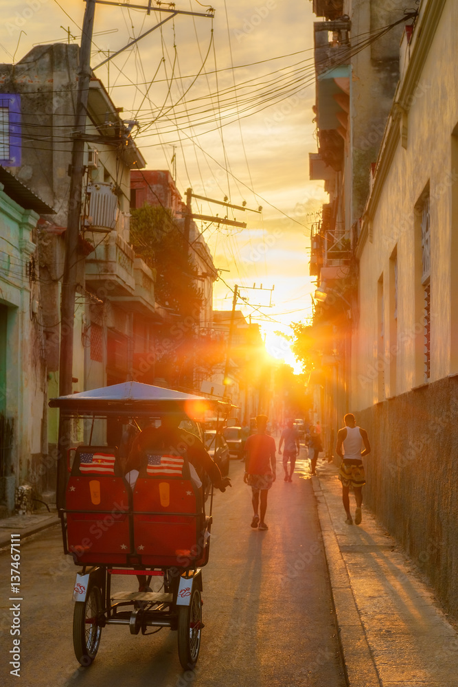 Fototapeta premium Street scene in Old Havana illuminated by the sun at sunset