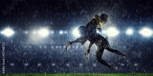 American football players at arena . Mixed media © Sergey Nivens