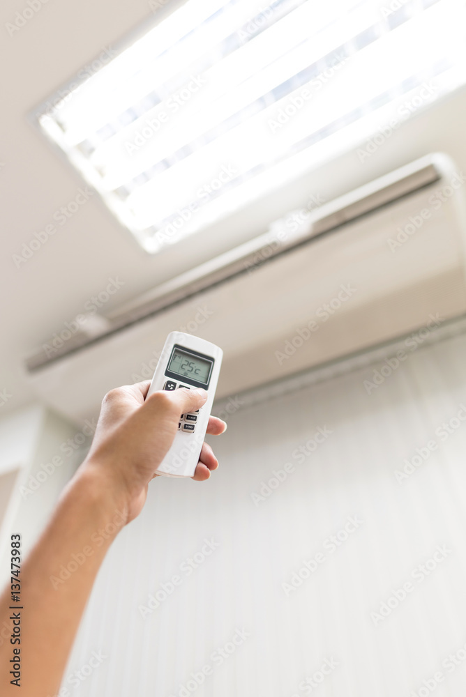 Hand hold air condition's remote and temperature setting is 25 degree celcius, Concept : Save Energy, Save World, Save money, Selective focus. Hand hold air condition's remote and temperature setting is 25 degree celcius, Concept : Save Energy, Save World, Save money, Selective focus.