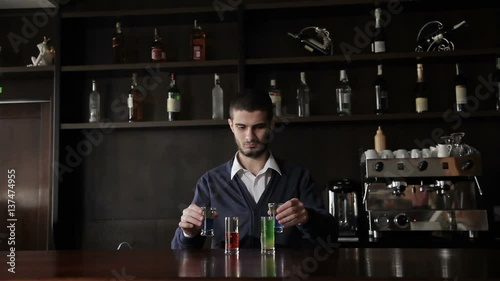 Barman puts the cocktails on the bar photo