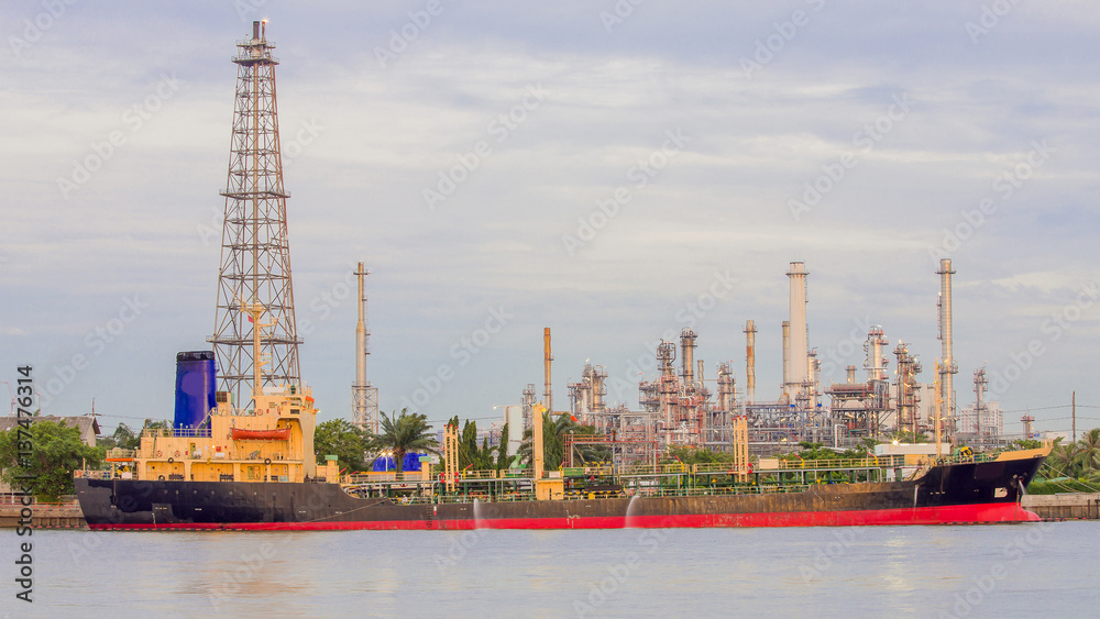 Oil refinery river front with transport ship, industrial background