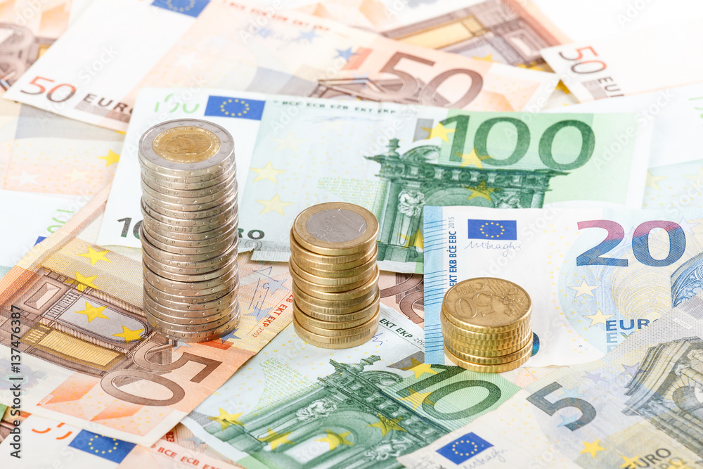 Euro coins stacked on euro banknotes background. Euro coins stacked on euro banknotes background.