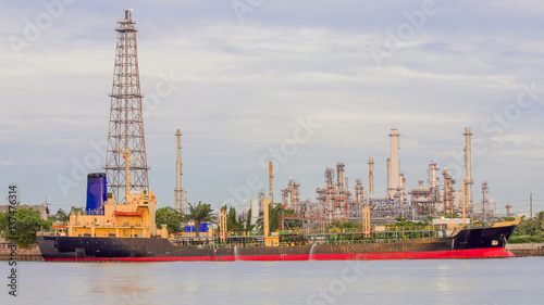 Oil refinery river front with transport ship  industrial background