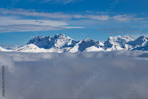 Mountains covered with snow and surrounded by clouds