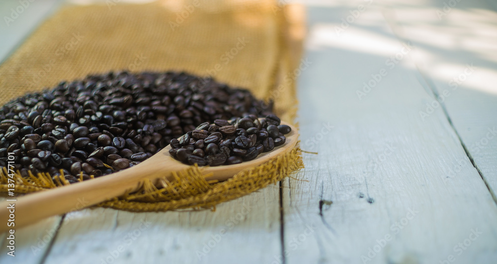 Coffee beans with sack on white wood desk. Coffee beans with sack on white wood desk.