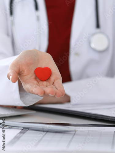 Unknown female doctor with stethoscope holding heart. Children's cardiology and medical care, stop abortation concept photo