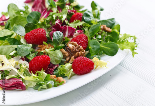 Green vegan salad with raspberry and nuts
