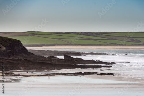 Expanse of beach leading to the sea with rock formations. photo