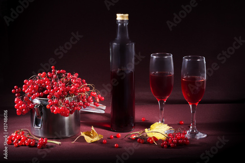 Красное вино и красные ягоды калины в металлической банке