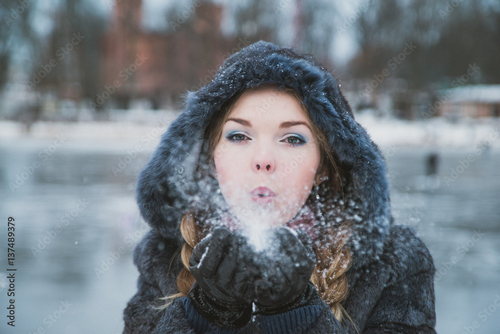 woman in a blue winter fur coat standing on the street in full growth woman in a blue winter fur coat standing on the street in full growth
