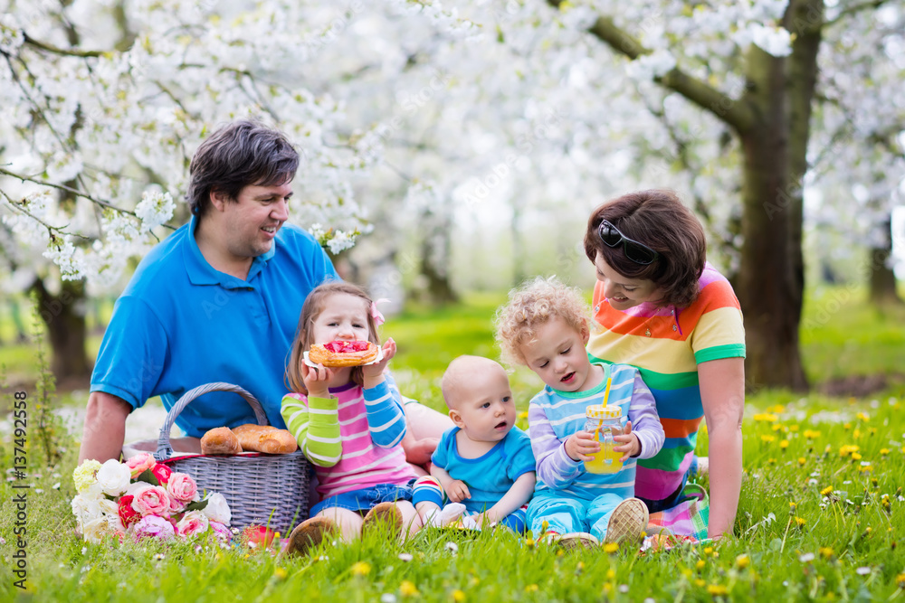 Fototapeta premium Family with children enjoying picnic in spring park