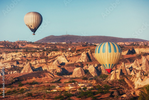 Hot air balloon flying over rock landscape at Cappadocia Turkey.