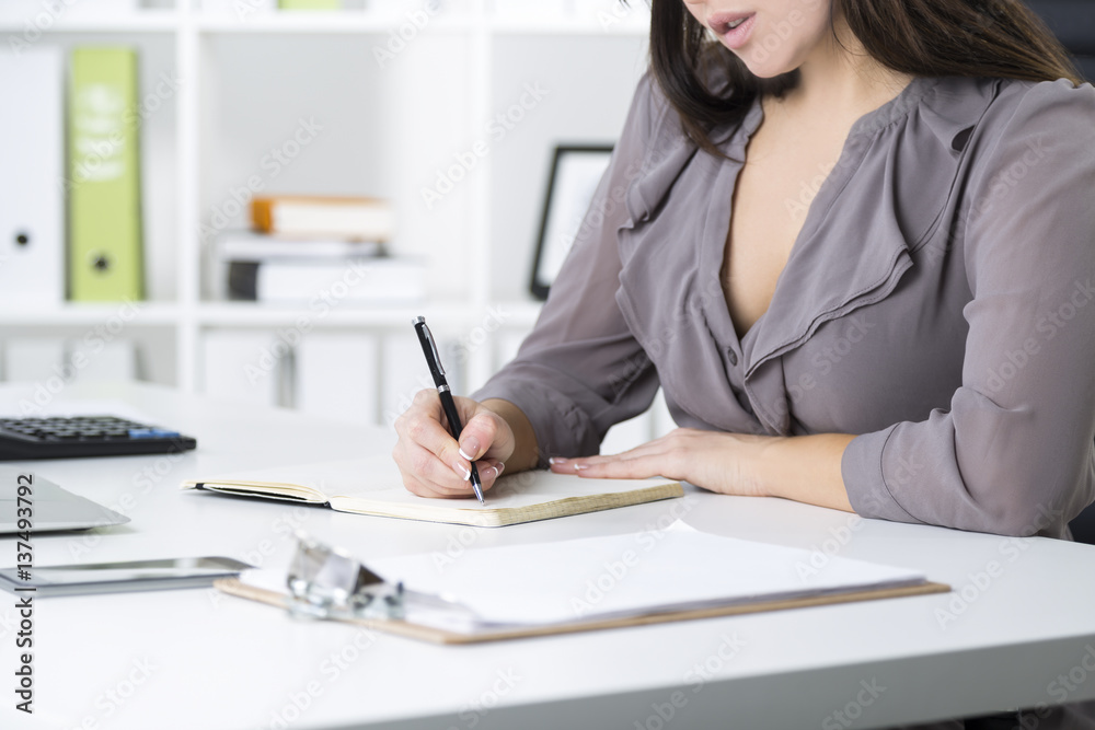 Close up of a businesswoman in gray writing Close up of a businesswoman in gray writing