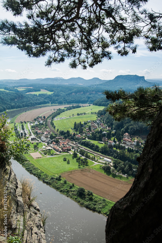 A view from observation desk of Bastei in Saxon Switzerland, Germany to Kurort Rathen and the river Elbe on a summer day.