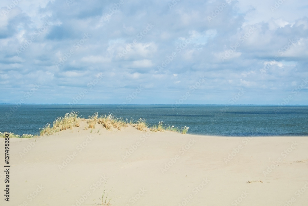The sand shore and the sea under the clouds at Lithuania, Curonian Spit, Nida dune.