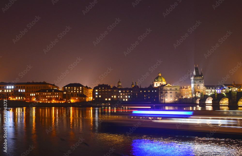 Skyline Prag with a passing Boat by Night