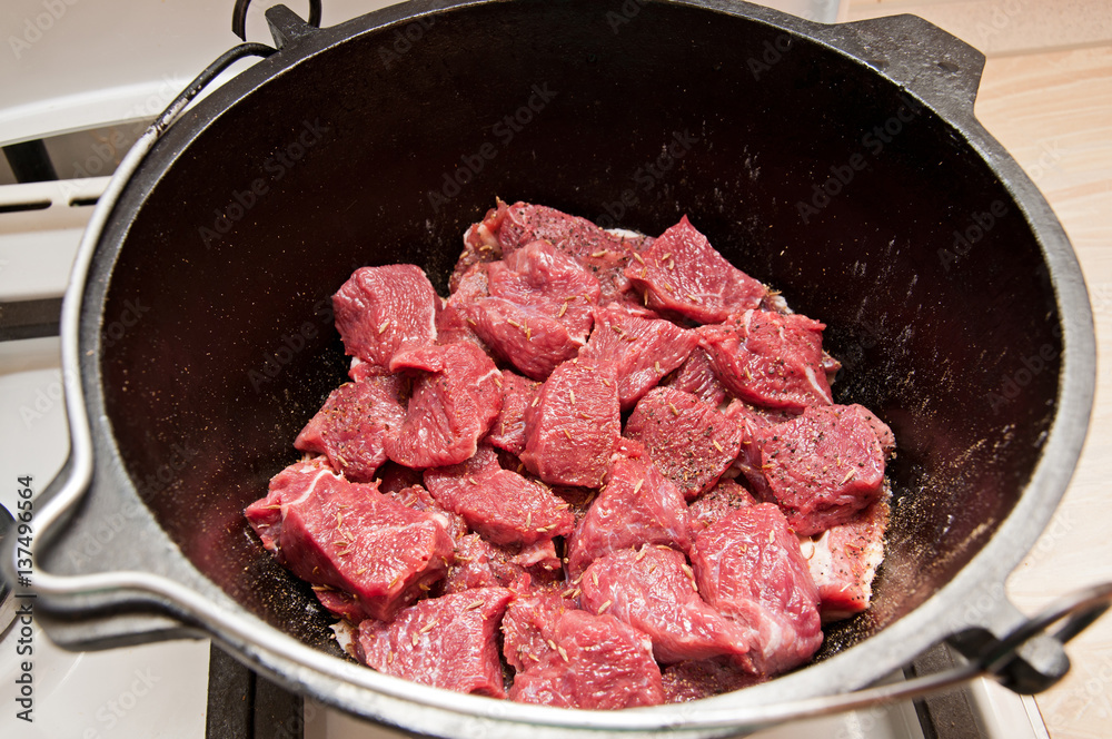 Raw meat in an iron pot Raw meat in an iron pot