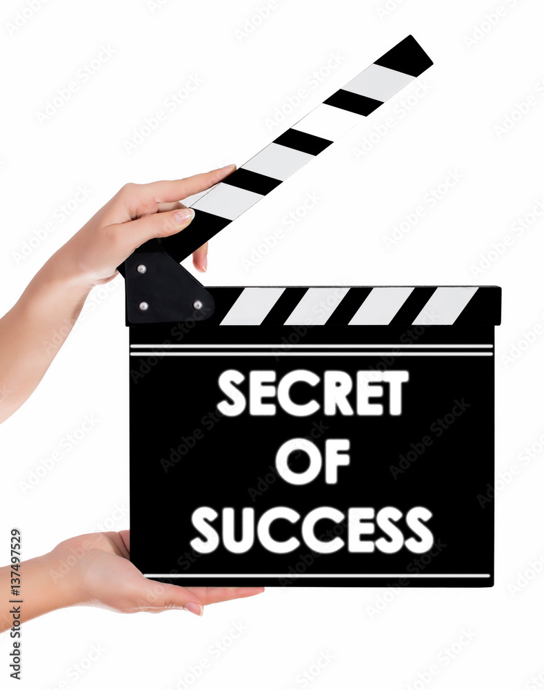 Hands holding a clapper board with SECRET OF SUCCESS text