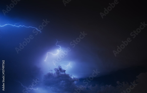 Lightning strike on the cloudy dark sky. Fantastic summer night 