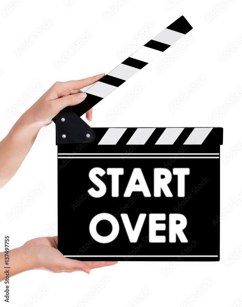 Hands holding a clapper board with START OVER text