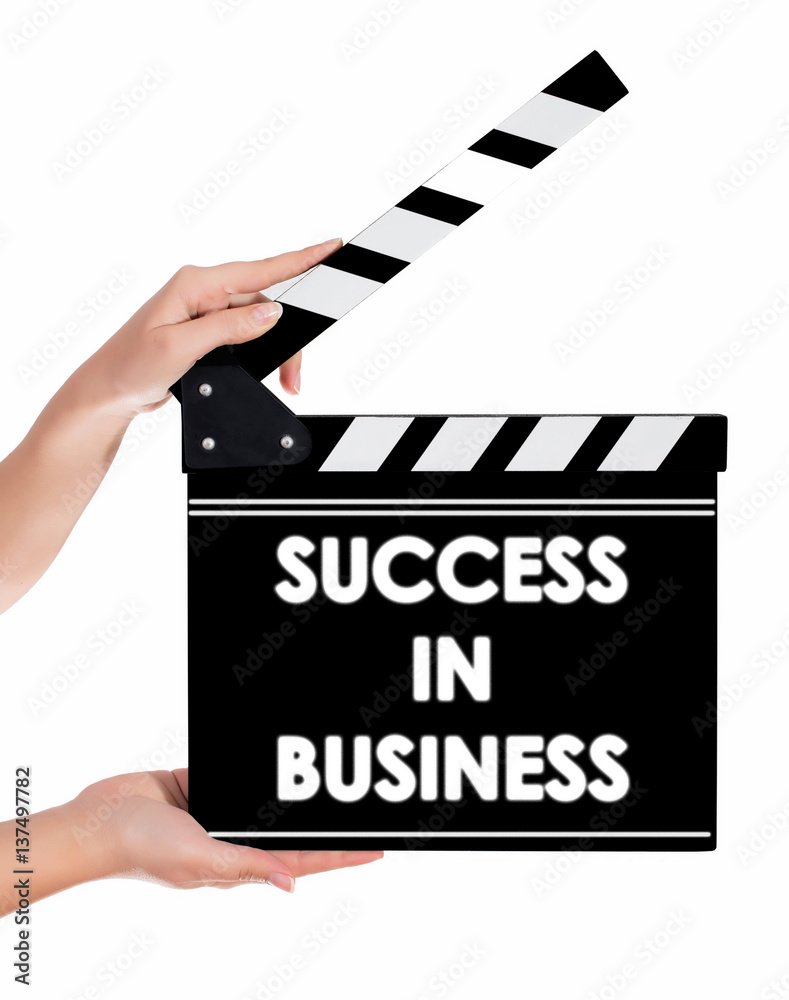 Hands holding a clapper board with SUCCESS IN BUSSINESS text