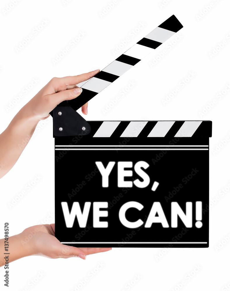 Hands holding a clapper board with YES WE CAN text